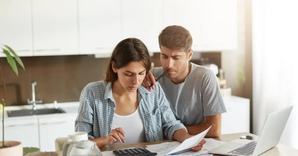 Couple adding up their wedding expenses