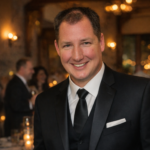 Adam Garrison Chicagoland Wedding MC & DJ smiling at an indoor wedding reception